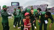 Pakistan's Babar Azam and Mohammad Amir help a young mascot during the T20 World Cup 2024 against India. (Getty)